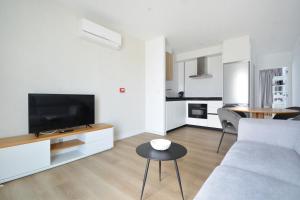 a living room with a couch and a tv and a table at GALIHOST - Apartamentos Vento Mareiro in Sanxenxo