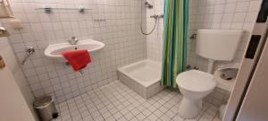 a white bathroom with a toilet and a sink at Rosa Canina W2 in Kellenhusen +3 photos