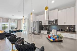 een grote keuken met witte kasten en een tafel en stoelen bij 4327 Create Memories in a Magical 5BD Home in Kissimmee