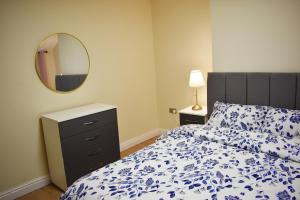 a bedroom with a bed and a dresser and a mirror at Birmingham City Centre Bedroom, Parking, WiFi, Kitchen, Living room in Birmingham +13 photos