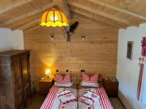 a bedroom with a bed with red and white pillows at Chalet Berghaus Rusch in Blaichach