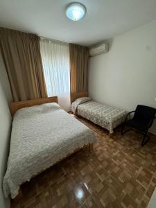 - une chambre avec 2 lits et une chaise dans l'établissement Apartment T2 for rent in Porto Novo, à Porto Novo