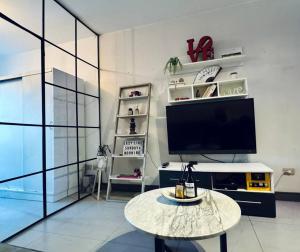 Una sala de estar con un televisor y una mesa. en Condo in Palermo with rooftop pool and security, en Buenos Aires