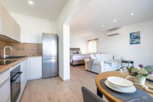 a kitchen and living room with a table and a couch at Apartmani Doro in Vela Luka