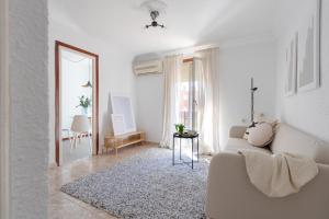 ein weißes Wohnzimmer mit einem Sofa und einem Spiegel in der Unterkunft Apartamento Esperanza by Clabao in Logroño