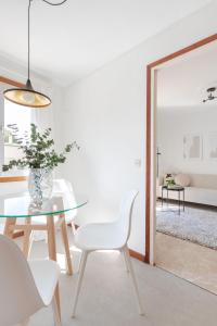 ein Esszimmer mit einem Glastisch und weißen Stühlen in der Unterkunft Apartamento Esperanza by Clabao in Logroño