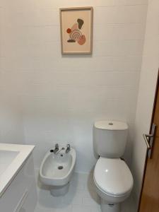 Un baño blanco con inodoro y lavabo. en Retiro da Bina, en Ovar