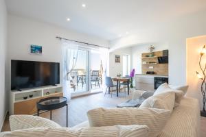 a living room with a couch and a tv at Apartmani Doro in Vela Luka
