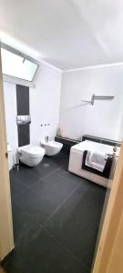 a white bathroom with two sinks and a toilet at Asimelia Luxury Apartment in Heraklio +37 photos