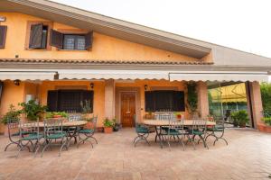 a patio with tables and chairs in front of a building at Villa Aureliana with pool near San Peter in Rome