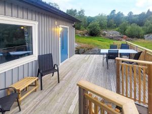 a wooden deck with a table and chairs on it at 4 person holiday home in Nösund in Nösund
