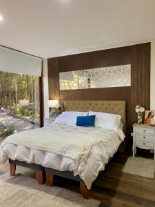 een slaapkamer met een groot bed met een groot raam bij Refugio Los Coigües in Puerto Varas