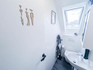 a white bathroom with a sink and a toilet at ALFA Stuttgart 3 Zimmer 6 Betten Apartment Wasen MercedesBenz MHP Arena l Bad I Küche l WIFI & SmartTV l 3BR & 6 Beds l Bathroom l Kitchen in Stuttgart +17 photos