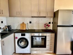 a kitchen with a washing machine and a refrigerator at Mandora's Sea View Apartment in Mochlos