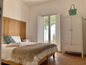 a bedroom with a bed and a dresser and a window at Casa Pompilio in Sagres