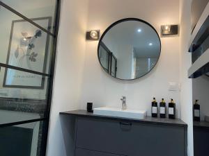 ein Badezimmer mit Waschbecken und Spiegel in der Unterkunft L'atelier d'Arches in Charleville-Mézières