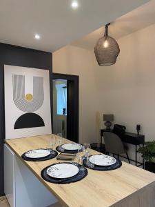 eine Küche mit einem Tisch mit Tellern und Gläsern darauf in der Unterkunft L'atelier d'Arches in Charleville-Mézières + 9 Fotos