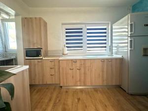 a kitchen with wooden cabinets and a window at Miva Apartments in Mangalia +5 photos