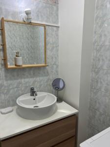 a bathroom with a white sink and a mirror at Appartement proche La Villette avec 2 balcons in Pantin +9 photos
