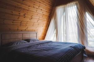 a bedroom with a bed and a window at Kazbegi Mountain View Cottage in Kazbegi