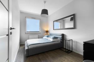 sypialnia z łóżkiem i lustrem na ścianie w obiekcie Blue Raven Downtown Apartments w Gdańsku