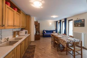 a kitchen with a table and a living room with a couch at Appartamento Dina in Livigno