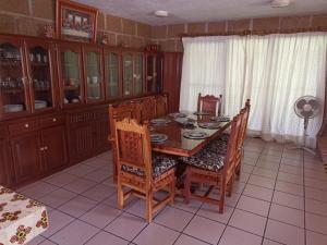 a dining room with a wooden table and chairs at Casa Vacacional con Alberca y Asador Tequisquiapan Querétaro Club de Golf in El Sauz Tequisquiapan