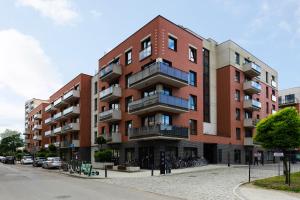 duży ceglany budynek z rowerami zaparkowanymi poza nim w obiekcie Blue Raven Downtown Apartments w Gdańsku