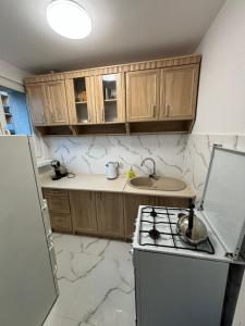 a kitchen with wooden cabinets and a stove top oven at Apartament Joanna in Kamienna Góra