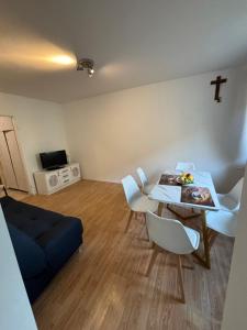 a living room with a table and chairs and a cross on the wall at Apartament Joanna in Kamienna Góra