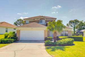 a house with a garage and a palm tree at Wonderland Villa in Haines City