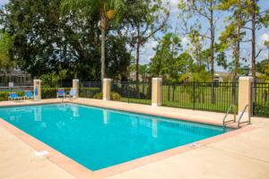ヘインズ・シティにあるThe Poolview Villa at Southern Dunesの椅子とフェンスのあるプール