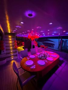 ein Esstisch auf einem Boot mit violetter Beleuchtung in der Unterkunft Osman in Istanbul