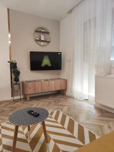 a living room with a tv and a coffee table at Exclusive Home Apartman in Miskolc +15 photos