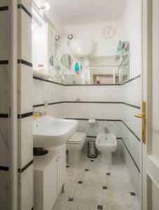 a white bathroom with a sink and a toilet at Il Gigliolo Apartment in Florence