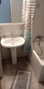 a bathroom with a sink and a shower with a tub at Anna's Apartment 4 - Sea View stay for 3 in Lixouri in Lixouri