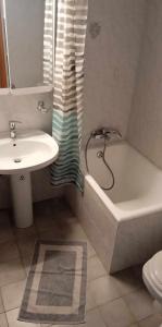 a bathroom with a sink and a tub and a toilet at Anna's Apartment 4 - Sea View stay for 3 in Lixouri in Lixouri +5 photos