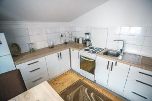 a small kitchen with white cabinets and a sink at Tabia Condo in Ljubuški