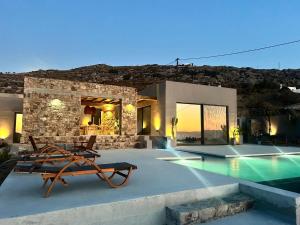 a villa with a swimming pool and some chairs at GR - Villa La Punta Mikri in Plaka