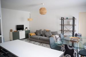 ein Wohnzimmer mit einer Couch und einem Glastisch in der Unterkunft Appartement 4 chambres proche Stade de France, parking et balcon sur jardin in Aubervilliers