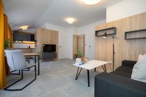 a living room with a couch and a table at ALURE RESIDENCES 11 - 24h self check-in & private parking next to the apartment building included, CITY CENTER right on SNP Square in a quiet passage, new building, best deal in town in Banská Bystrica