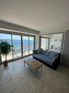 圣马克西姆Appartement vue mer Sainte Maxime的客厅里有一张蓝色的沙发，可以看到海景
