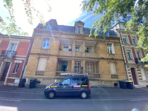 ein Van vor einem Gebäude geparkt in der Unterkunft L'atelier d'Arches in Charleville-Mézières