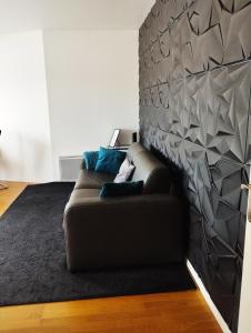 sala de estar con sofá contra la pared en ORCHIDÉES CHOISY 5Pers Parking Wifi, en Choisy-le-Roi