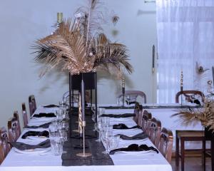 a long table with plates and glasses and plants on it at Viesu nams “Bauļi” in Piltene