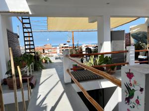 einen Balkon mit Pflanzen und einer Leiter auf einem Gebäude in der Unterkunft Bravo Hostels: Surf House in Punta Hermosa