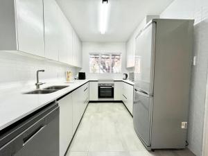 a kitchen with white cabinets and a stainless steel refrigerator at Thornhill Tranquility in Pretoria