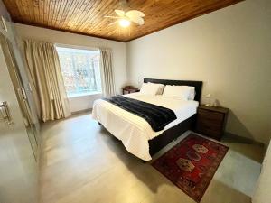a bedroom with a large bed and a window at Thornhill Tranquility in Pretoria