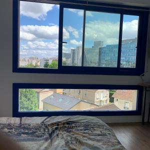 クルブヴォアにあるParis La Défense - Santorin Apartment with jacuzziのベッドルーム1室(市街の景色を望む窓付)
