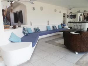 a living room with blue couches and a kitchen at Casa Las iguanas in Acapulco